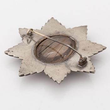 A brooch in grey metal set with rutile quartz.