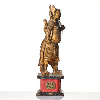 A gilt and lacquered standing figure of a guardsman, Qing dynasty.