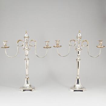 A pair of early 19th century silvered brass candelabra for three candles.