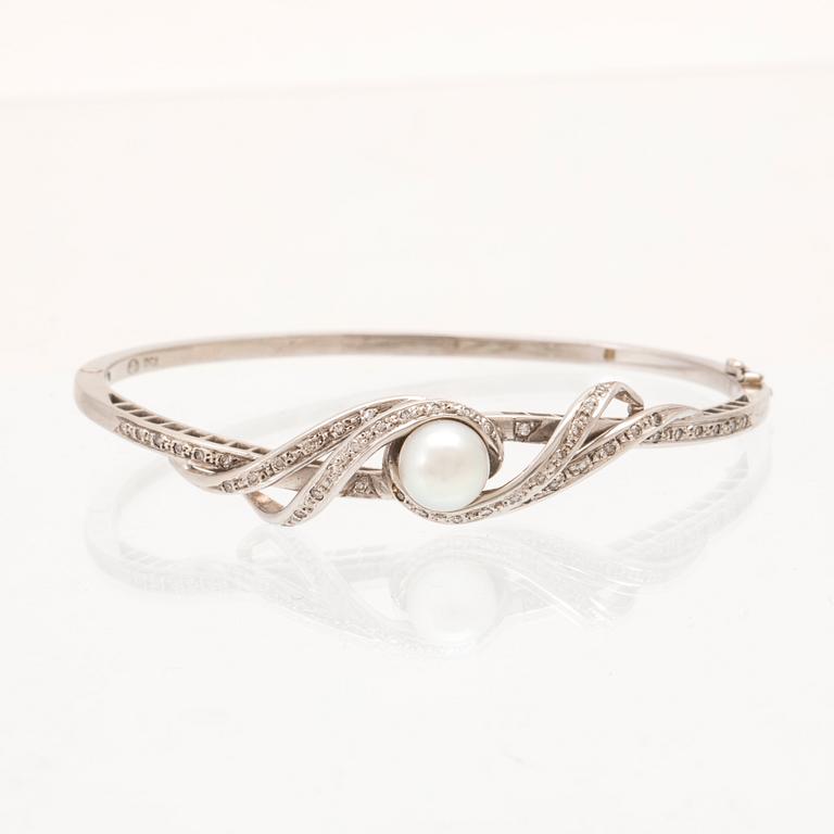 An 18K white gold bracelet with single-cut diamonds and a cultured pearl.