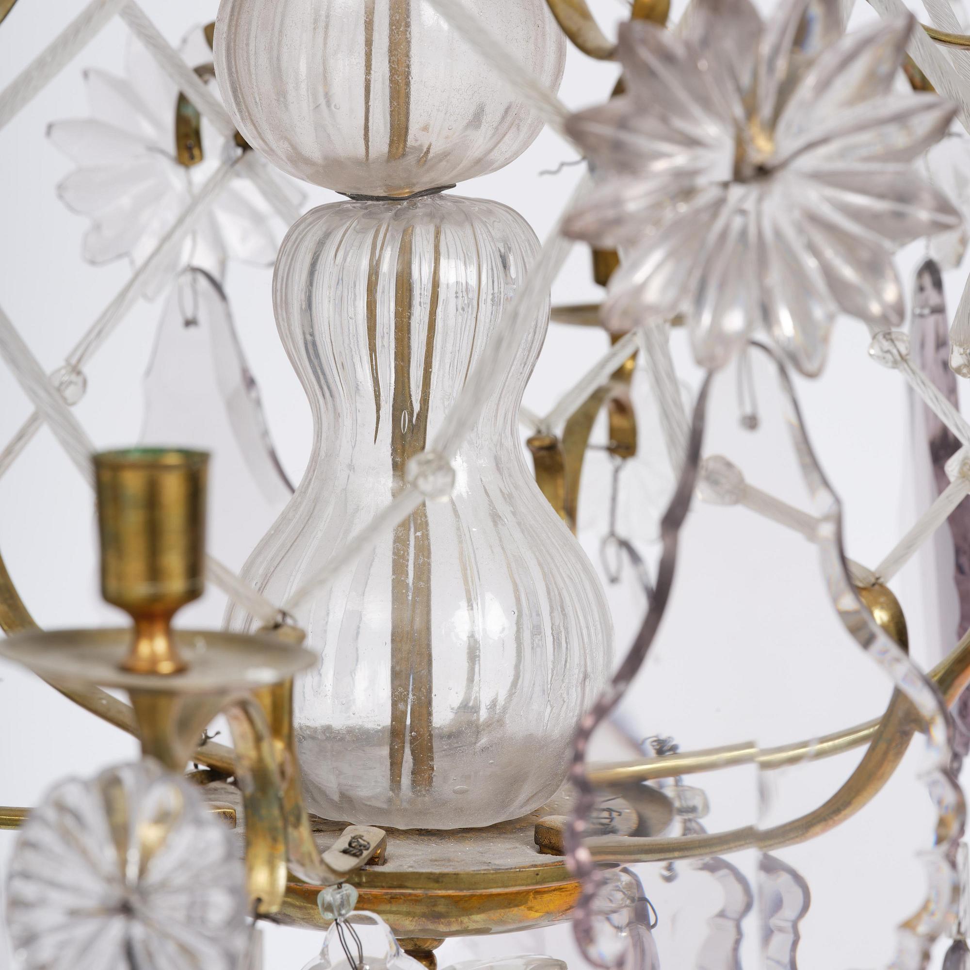 A near pair of rococo-style gilt brass and cut glass six-branch chandeliers, 19th century incorporating older elements.