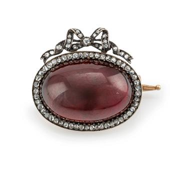 520. En brosch guld och silver med en cabochonslipad granat och rosenslipade diamanter, Fabergé.