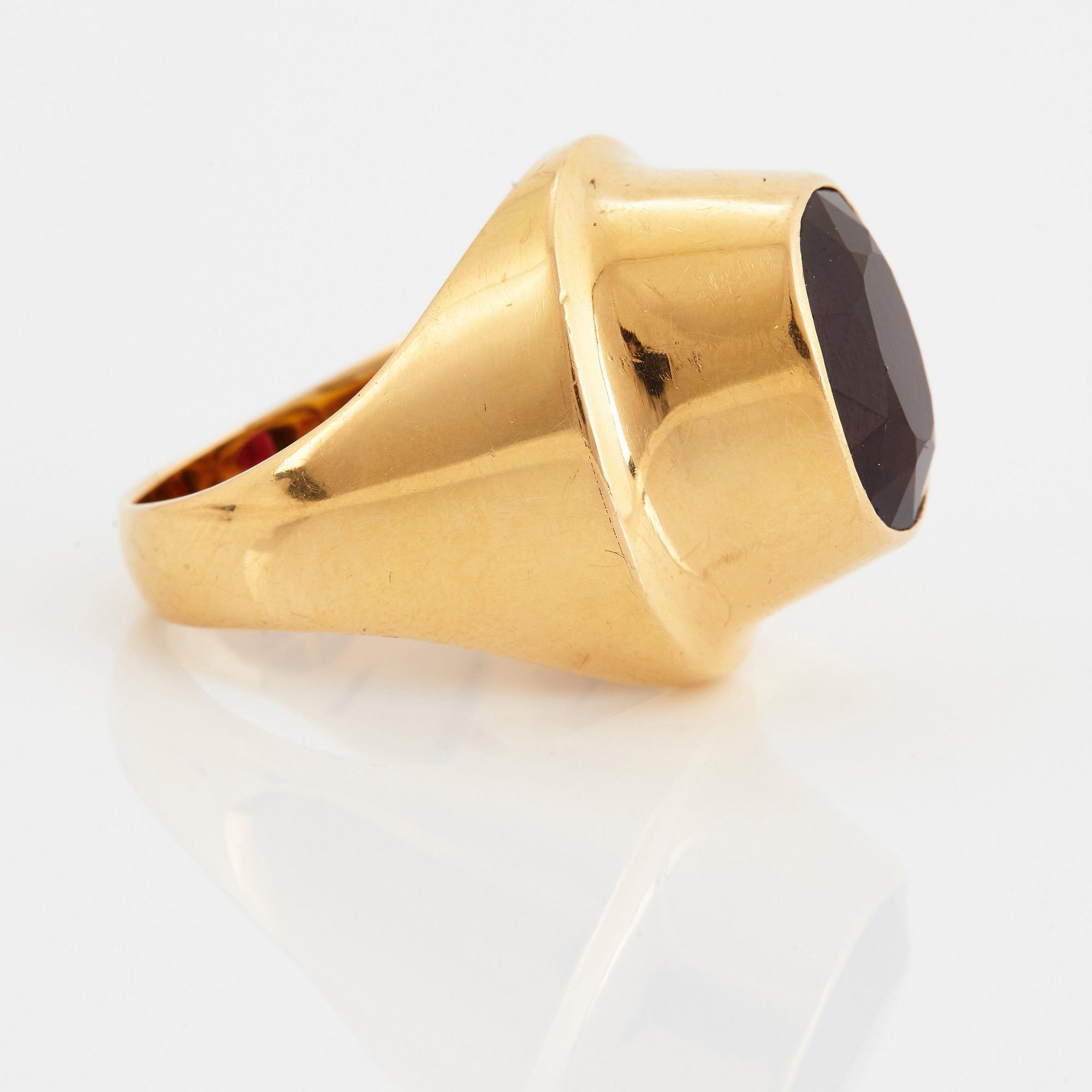 A Sigurd Persson 18K gold ring set with a faceted garnet.