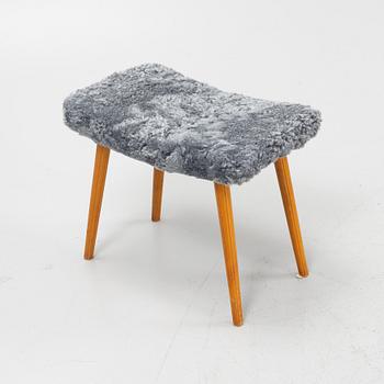A mid 20th Century stool with new sheepskin upholstery.