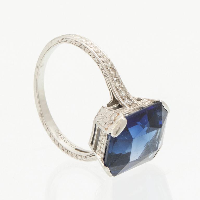 A Shreve & Co Platinum Ring set with a Synthetic Sapphire and Round Brilliant Cut Diamonds.