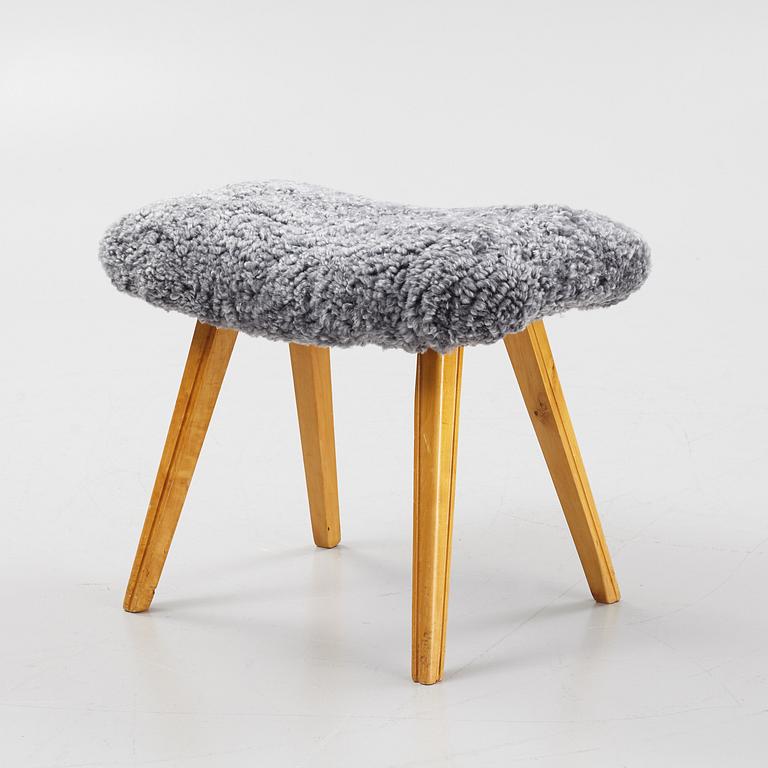 A birch stool with new sheepskin upholstery.
