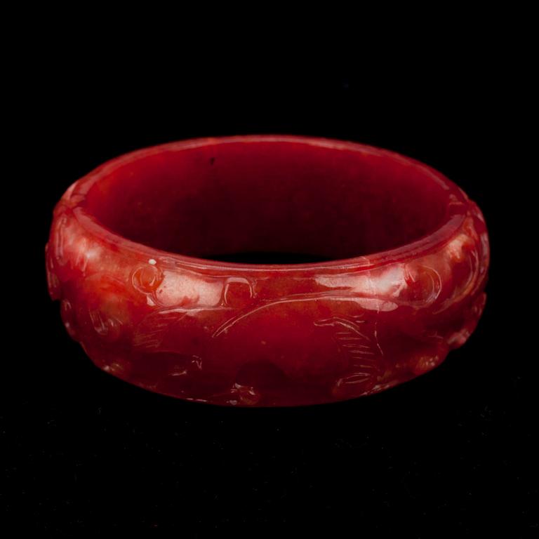 ARMBAND, rödfärgad jadeit, 1900-talets senare hälft.