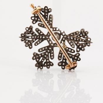 A brooch in the shape of a snow-flake by Fabergé, decorated with old and rose-cut diamonds.