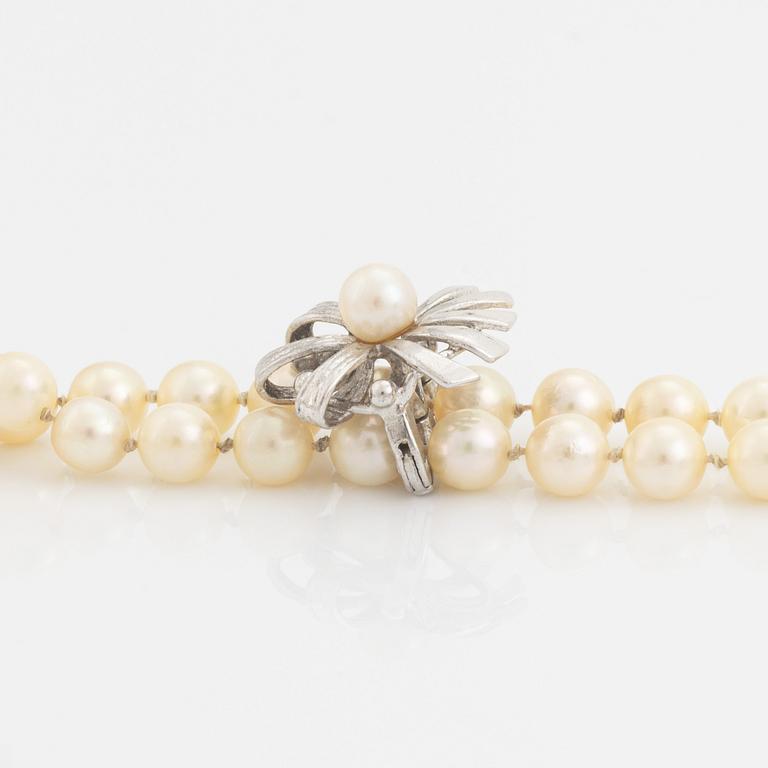 A cultured pearl necklace with silver divider.