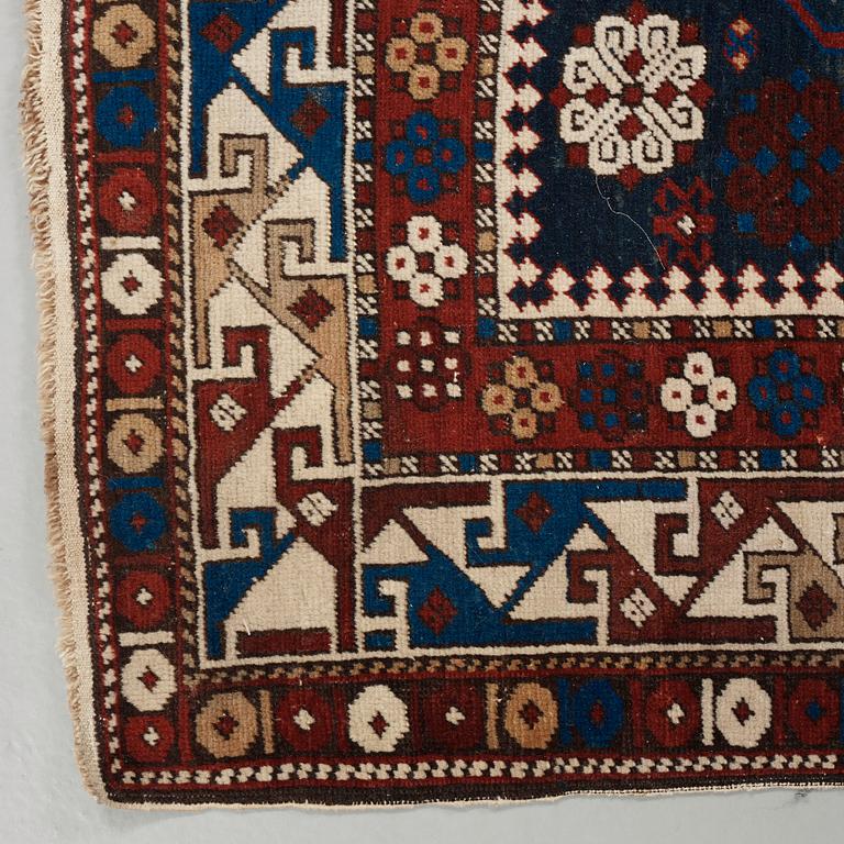 A RUG. A semi-antique Kuba/Shirvan. 165,5 x 129,5 cm (as well as one end with one cm flat weave).