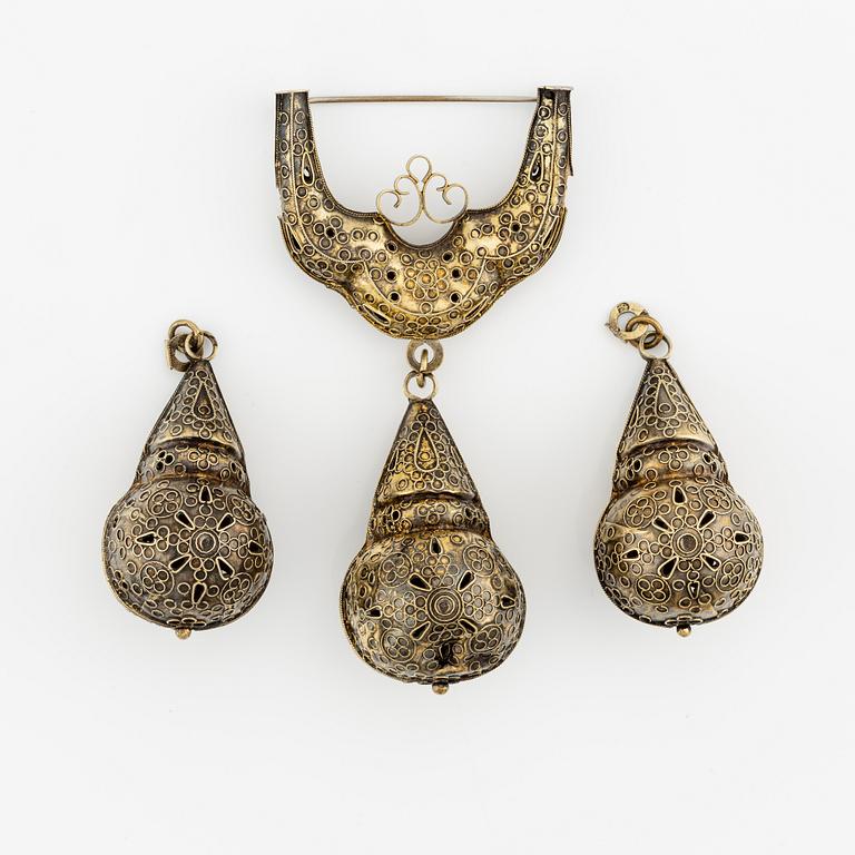 A brooch and two pendants, silver.