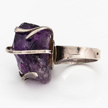 A silver ring with an amethyst.