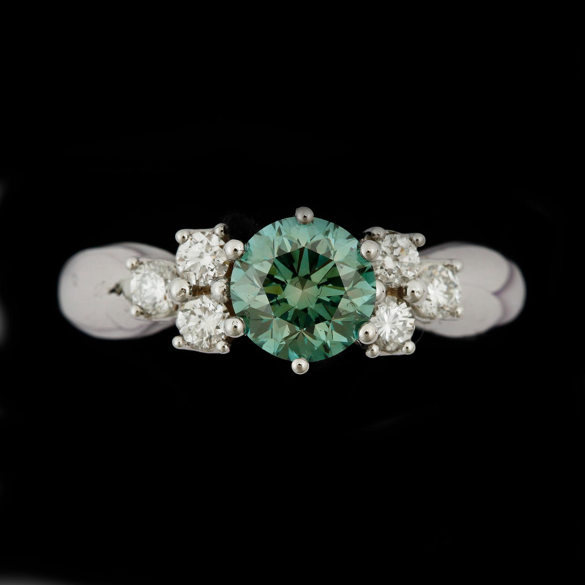 RING, 18k vitguld med briljantslipade diamanter, mittsten grön diamant ca1,04ct. övriga tot ca0,29ct. Vikt 5,5g.