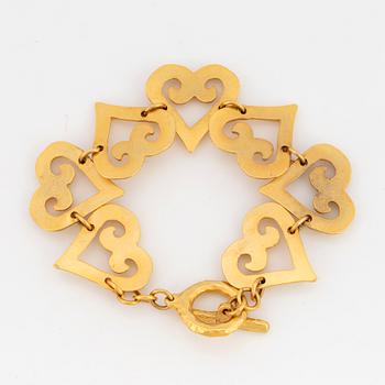 YVES SAINT LAURENT, Hammered gilt metal bracelet, links designed as hearts.