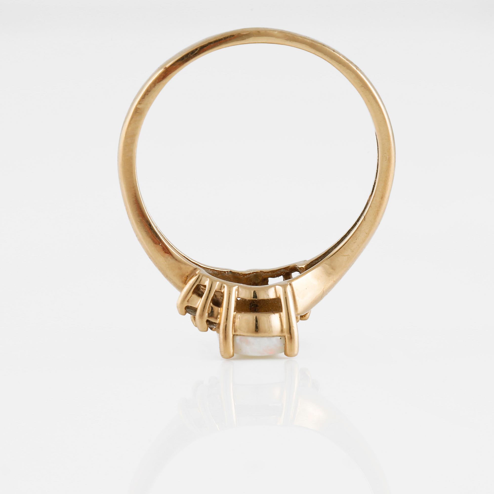 RING, 10K guld med 6 briljantslipade diamanter samt cabochonslipad vit opal. Vikt 2,4 gram.