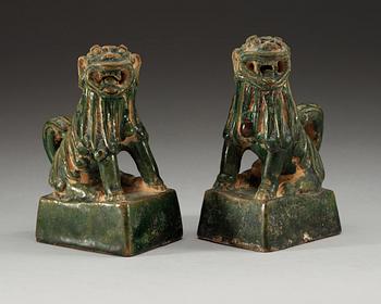 A pair of green glazed figures of 'Buddhist Lions', Ming dynasty.