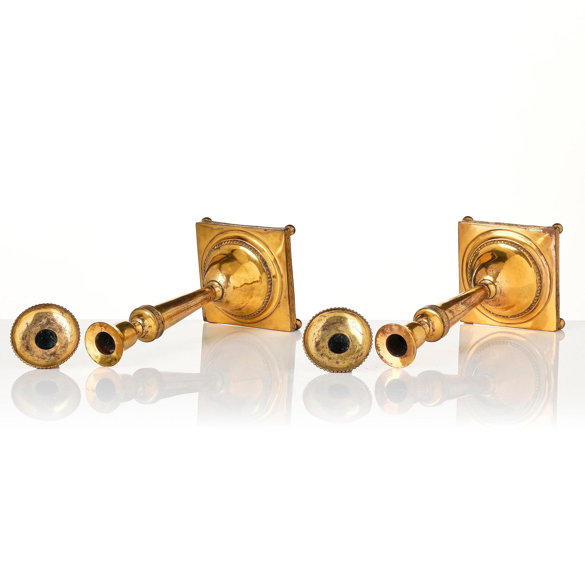 A pair of late George III gilt-copper candlesticks, early 19th century.