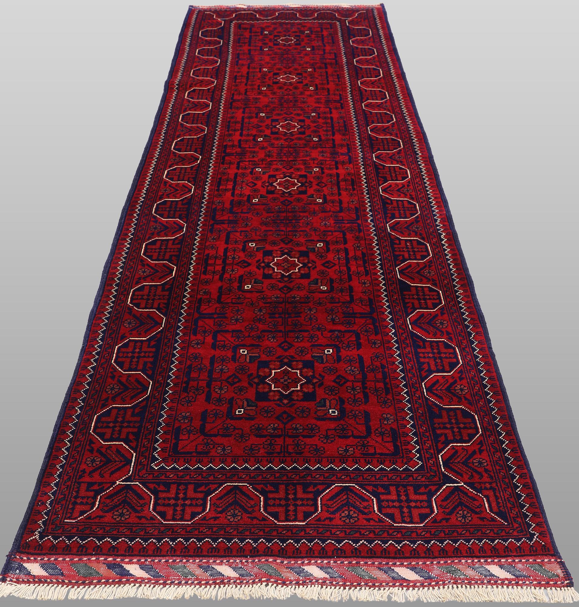 A Afghan runner carpet, 304 x 84 cm.
