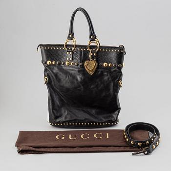 Gucci, a black leather handbag.