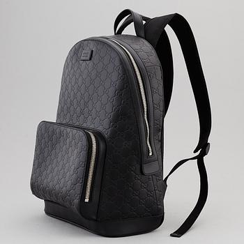 GUCCI, a black leather backpack.