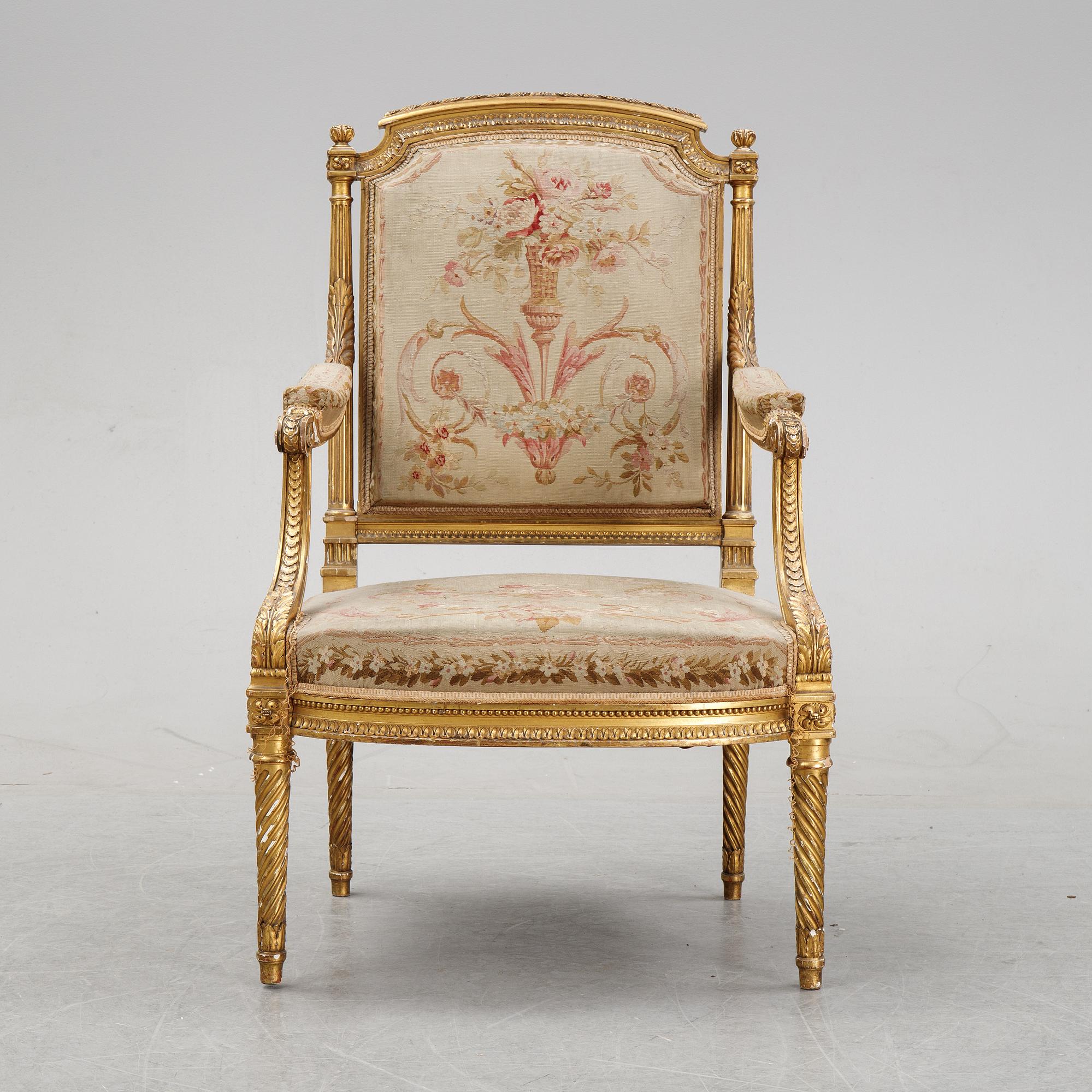 A gilt Louis XVI style armchair from around the year 1900.