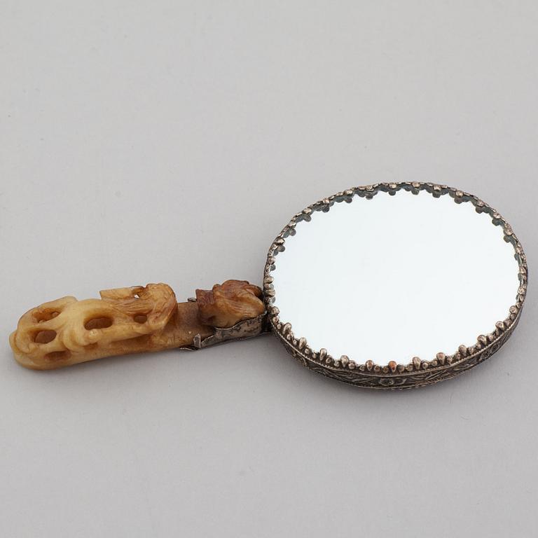 A silver gilt copper mirror with nefrite handle in the shape of a belt hook.
