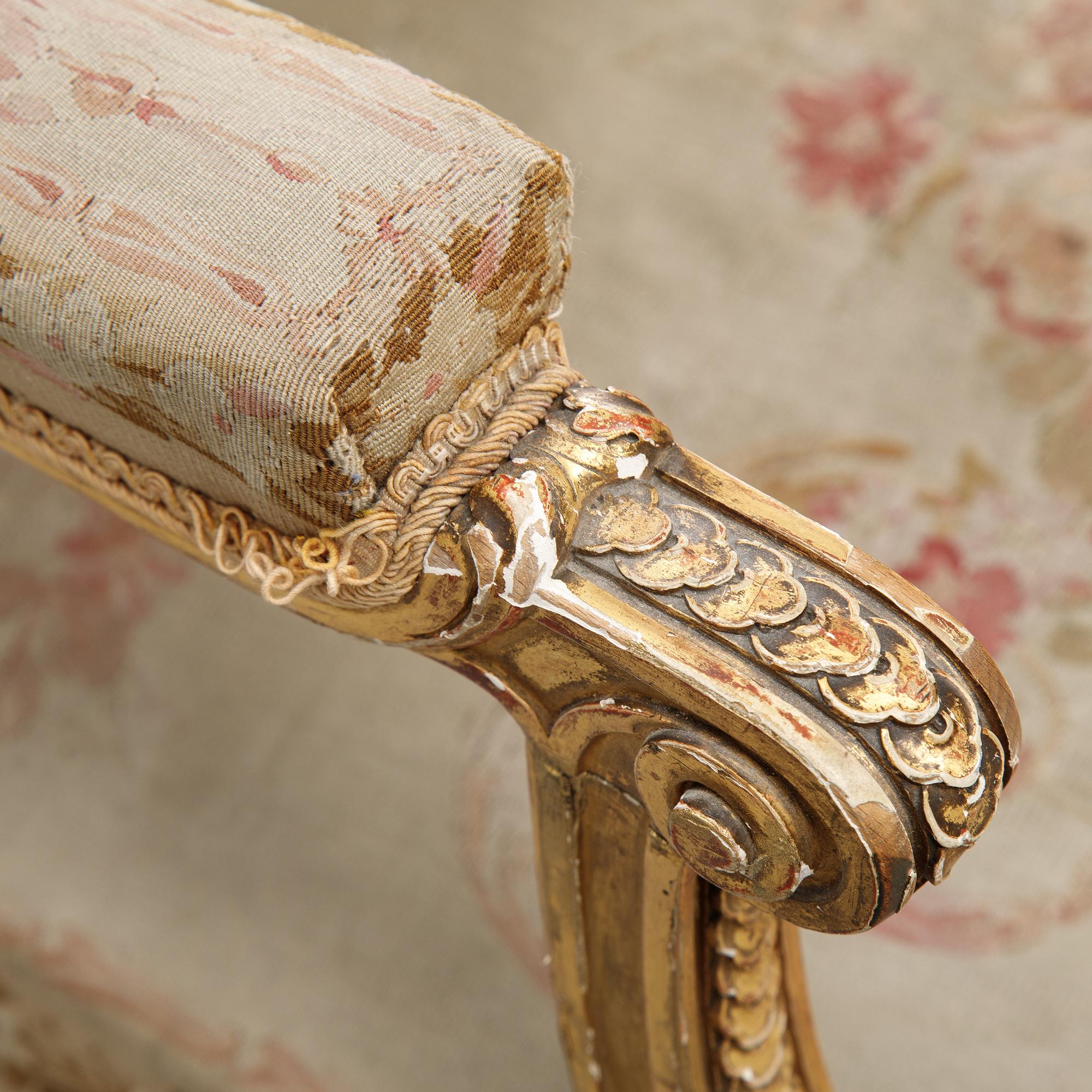 A gilt Louis XVI style armchair from around the year 1900.