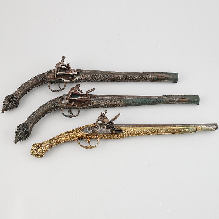 A pair of miquelet pistols and an flintlock pistol, 18/19th Century.