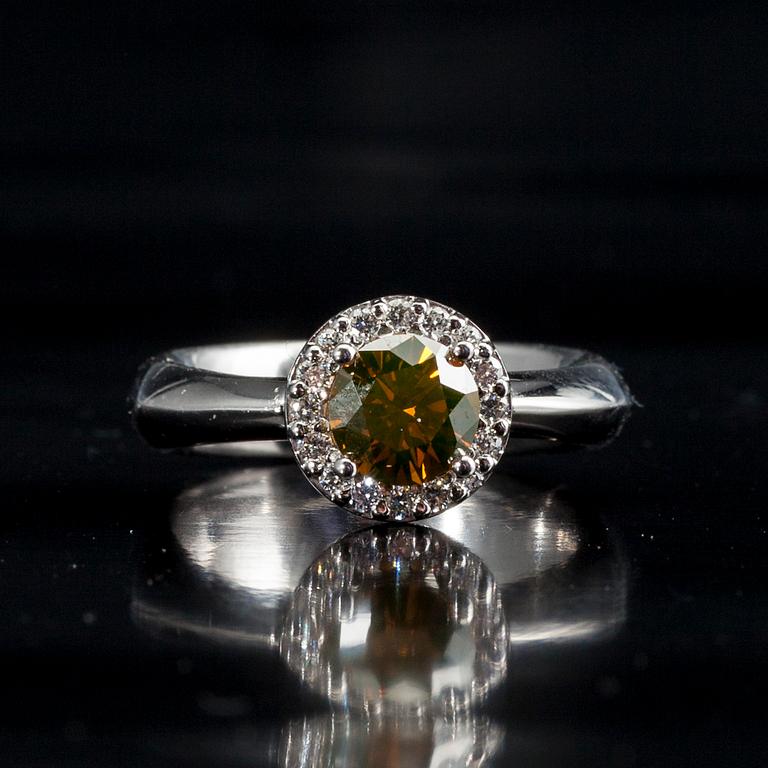 RING, 18K vitguld, briljantslipad diamant 1,11 ct. 16 st. diamanter tot. 0,22 ct. Vikt 8,8 g. Intyg.