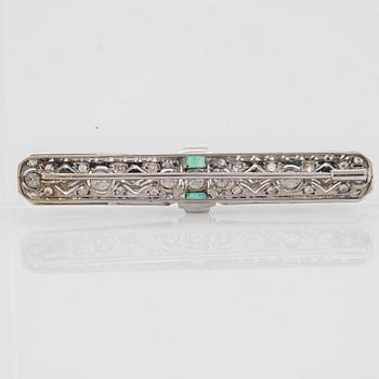 An 18K white gold brooch set with old- and eight-cut diamonds and faceted emeralds.