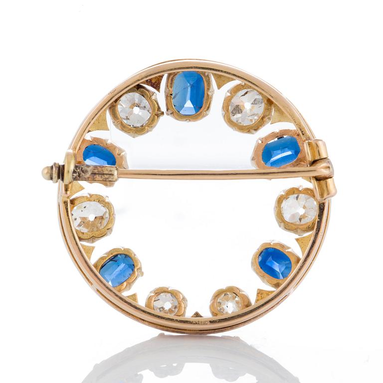 A brooch in 14K gold set with old- and rose-cut diamonds and faceted sapphires.