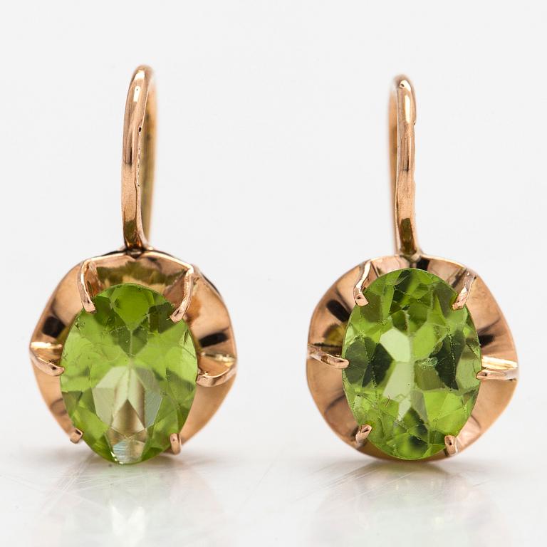 A pair of 14K gold earrings with peridots.