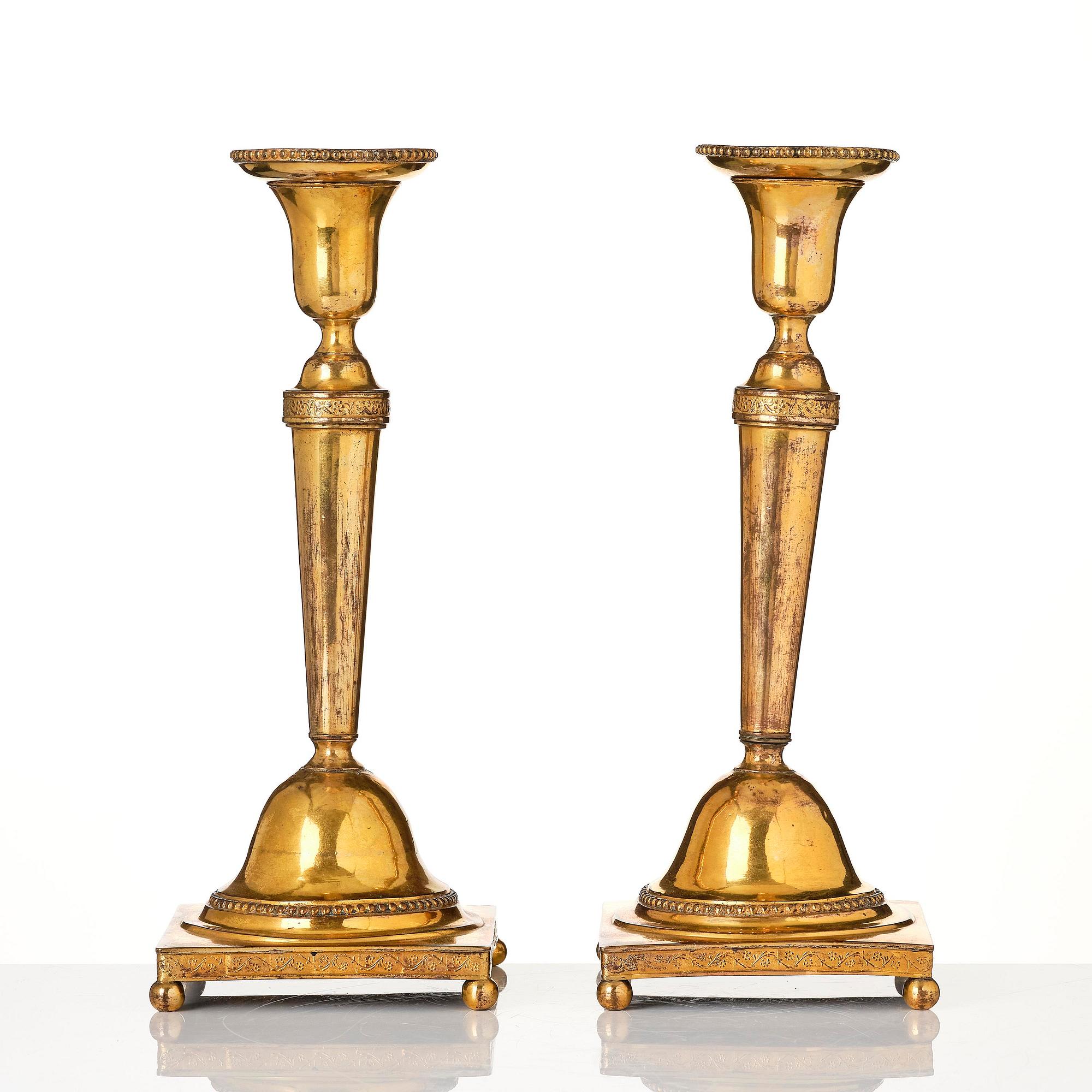 A pair of late George III gilt-copper candlesticks, early 19th century.