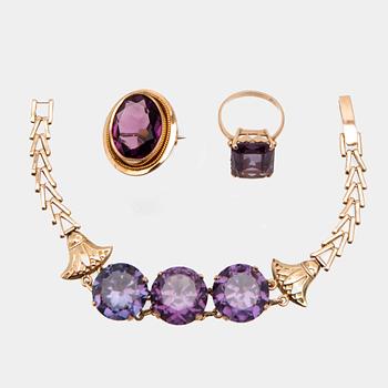 Bracelet, ring, and brooch in gold with synthetic colour-changing sapphires and glass.