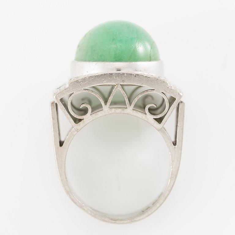 An 18K white gold ring set with a cabochon-cut emerald and round- and eight-cut diamonds.