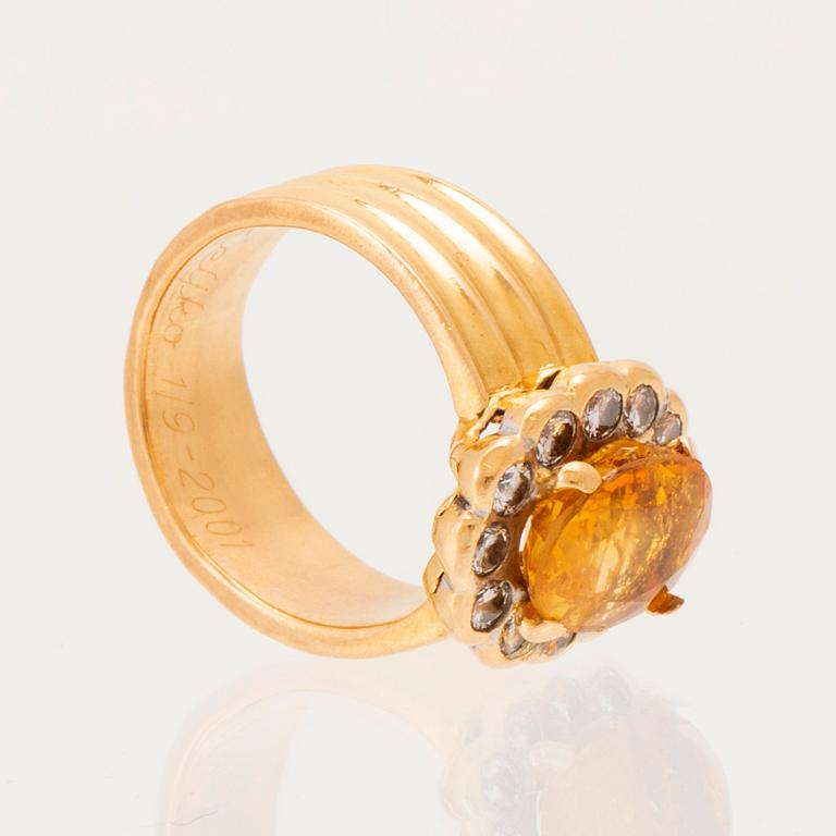 A 22K gold carmosé ring with an oval faceted yellow sapphire and round brilliant-cut diamonds.