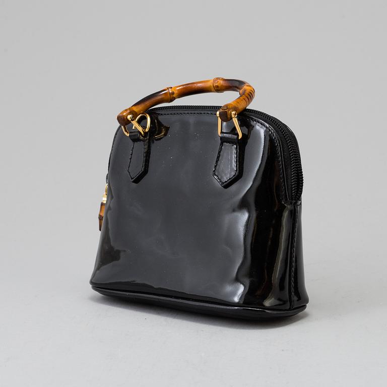 A Gucci patent leather bag with bamboo handle.