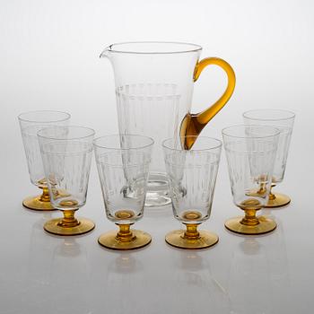 A glass pitcher with six glasses from around the 1920s.