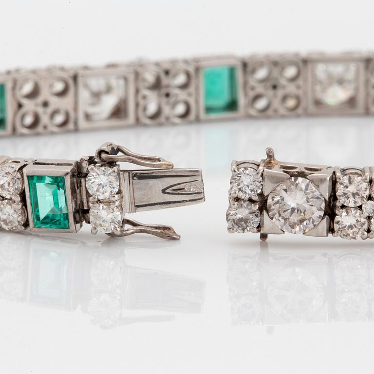 A platinum bracelet set with round brilliant- and old-cut diamonds and faceted emeralds.