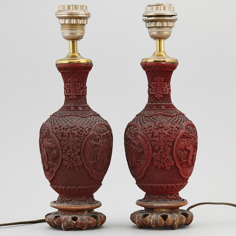 A pair of Chinese red lacquered vases, turned into table lamps, 20th century.