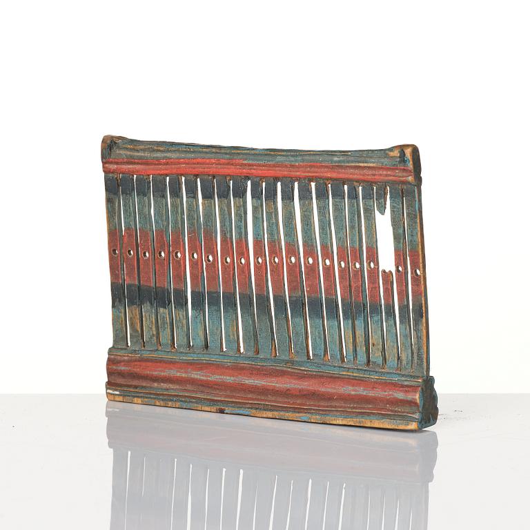 A Swedish carved and polychrome painted weaving tool from Hälsingland, 19th century.