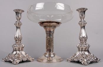 SKÅL PÅ FOT SAMT LJUSSTAKAR ett par, nysilver, 1900-talets första hälft.