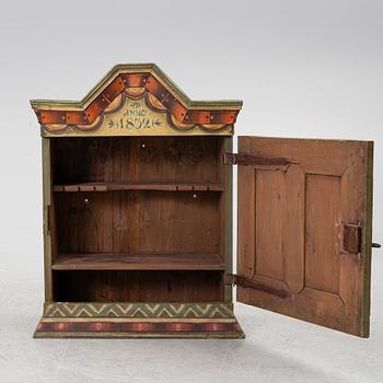 A hanging cabinet, dated 1832.