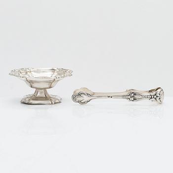 A silver sugar tong by Johan Warjus, and a silver salt cellar by Adolf Sper, St Petersburg 1856 and 1849.