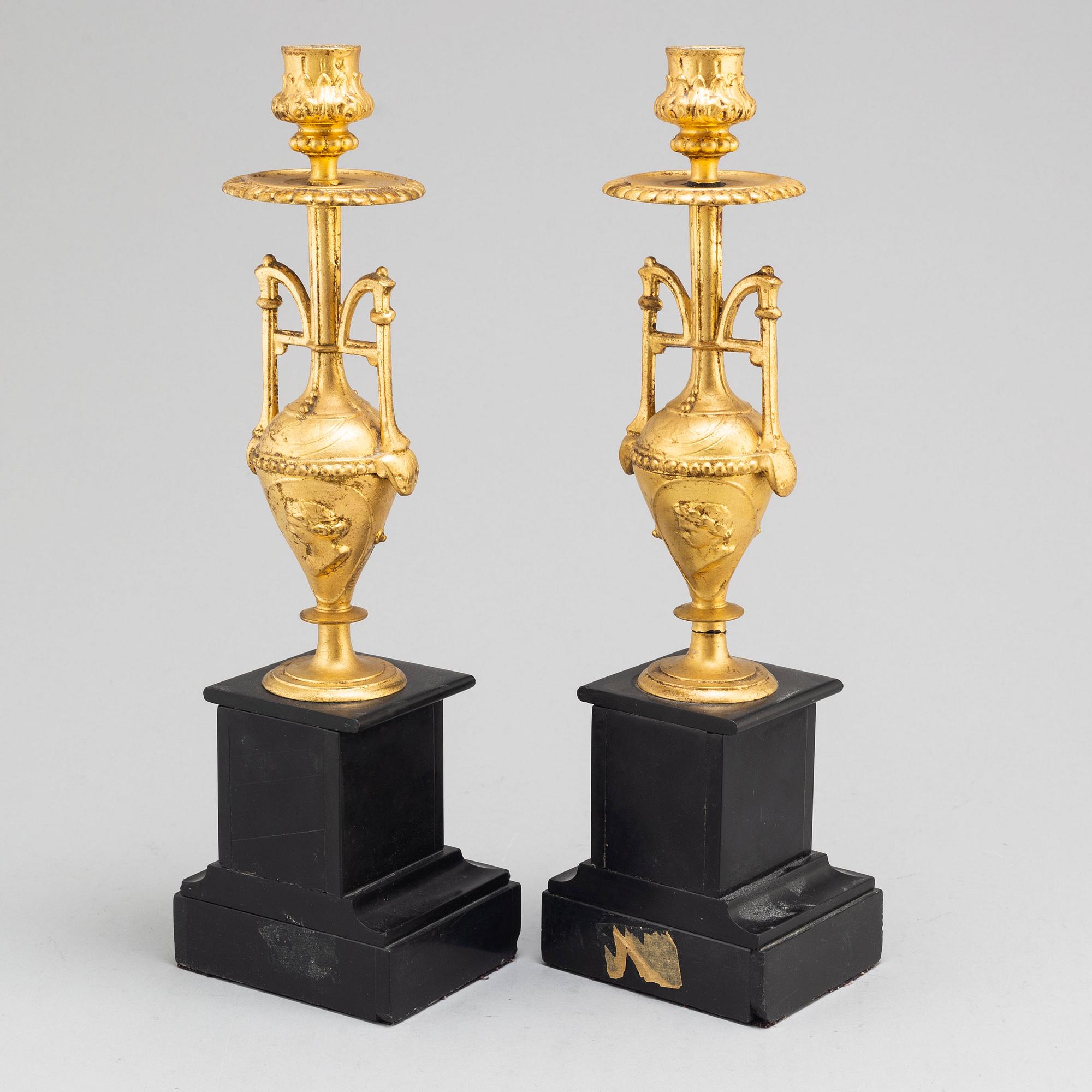A late 19th century table clock and a pair of candlesticks.