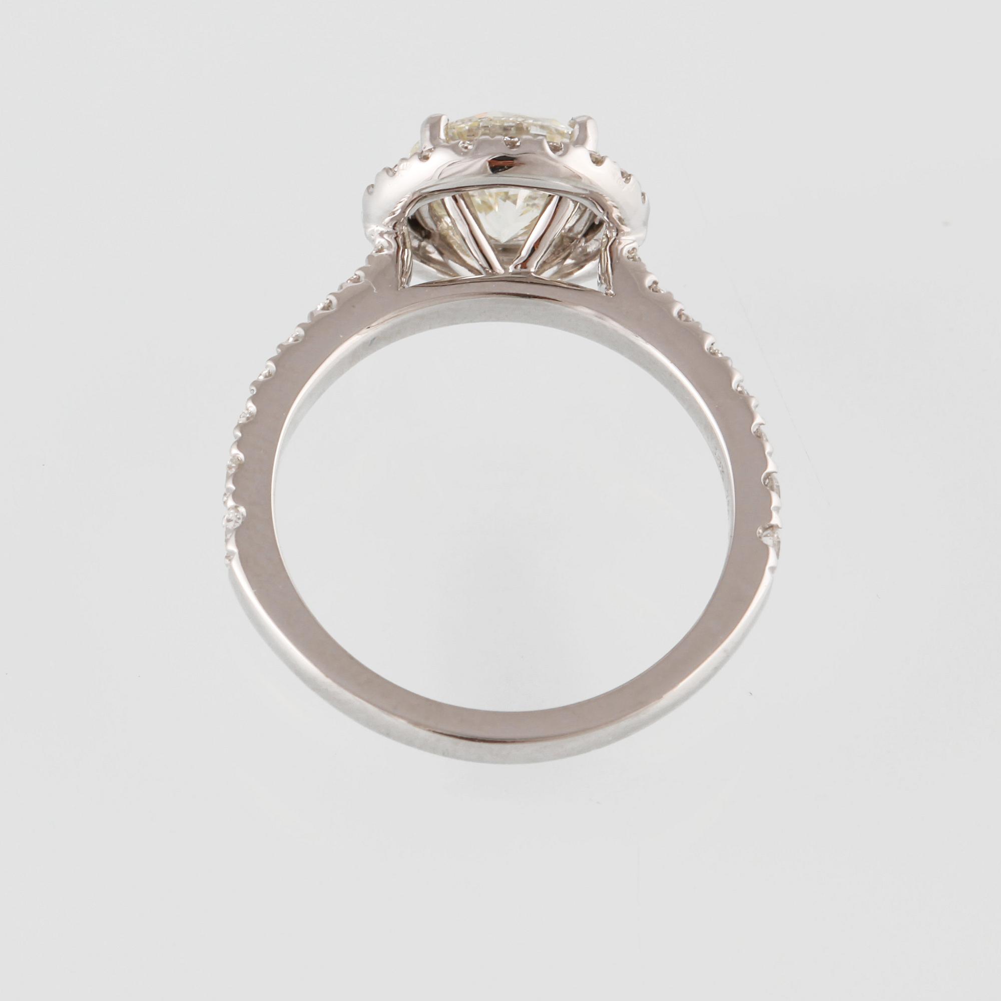 RING, 18K vitguld med en briljantslipad diamant 1.44 ct samt små briljantslipade diamanter 0.50 ct. Vikt 4,6 gram.