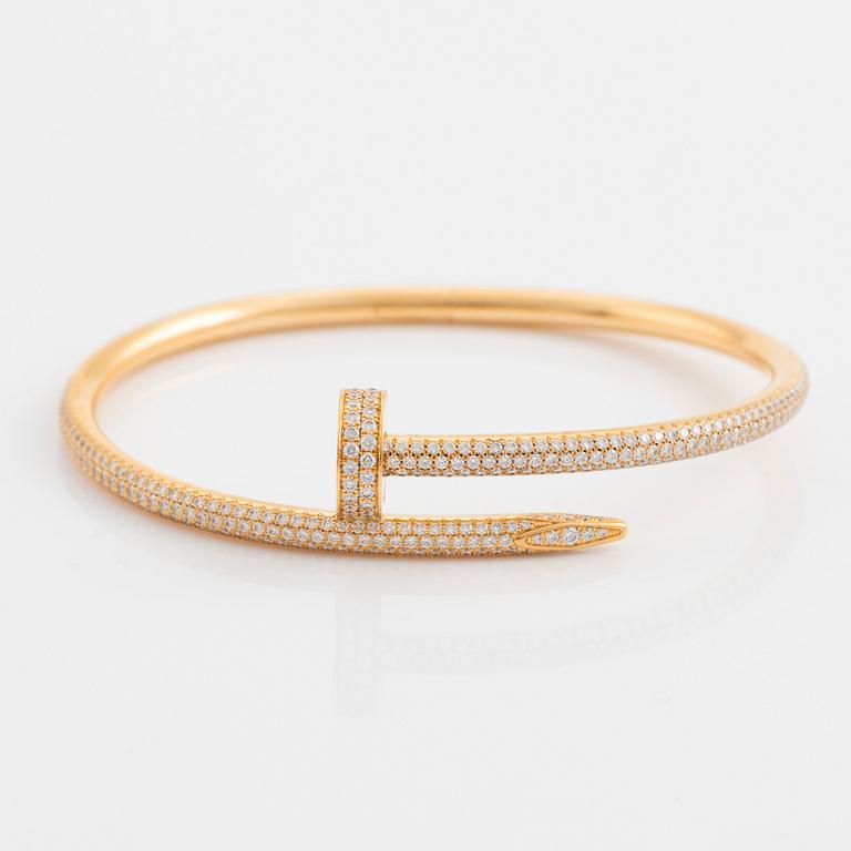 A Cartier "Juste un Clou" bracelet in 18K gold set with round brilliant-cut diamonds.