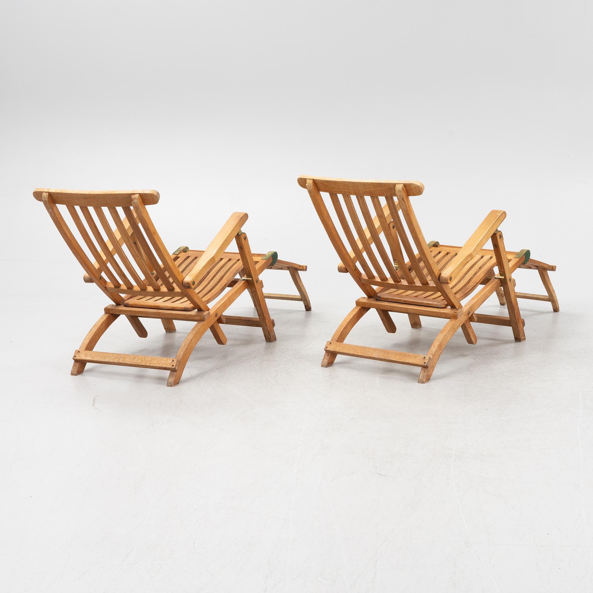 A pair of teak deck chairs and a table, 21st Century.