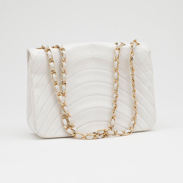 CHANEL, a white leather shoulder bag.