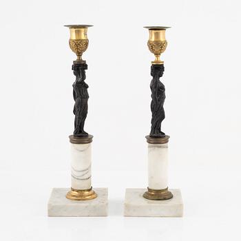 A pair of Gustavian-style ormolu, patinated bronze and marble candelsticks, circa 1900 incorporating older elements.